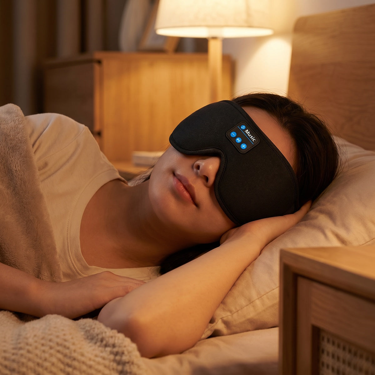 Woman sleeping in a NapNest Bluetooth sleep mask with built-in speakers
